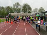 Groep mensen staan op het sportveld.